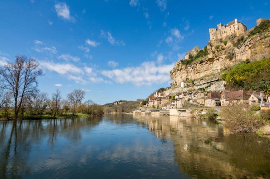 Ein Fluss mit einem Schloss auf einem Felsen im Hintergrund