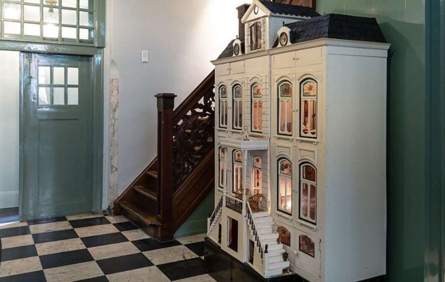Ein Puppenhaus steht in einem Flur neben einer Treppe
