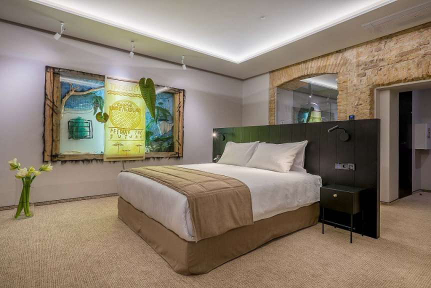 Ein Hotelzimmer mit einem Bett und einem Gemälde an der Wand