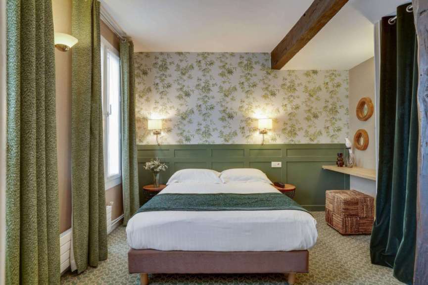 Ein kleines Schlafzimmer mit einem Bett und grünen Vorhängen