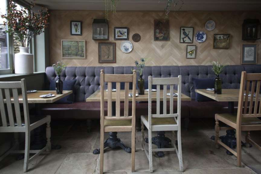 Tische und Stühle in einem Restaurant mit Bildern an der Wand