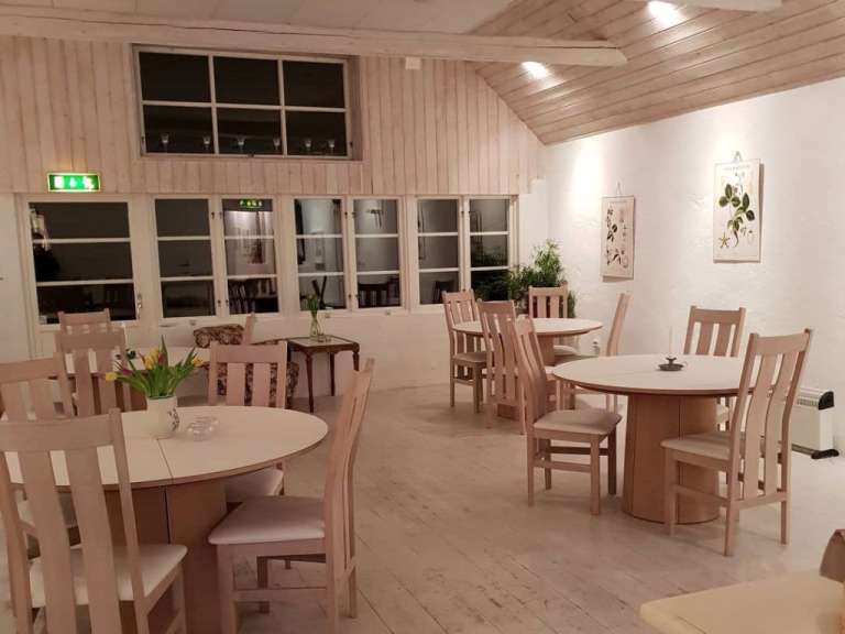 Ein Esszimmer mit weißen Tischen und Stühlen
