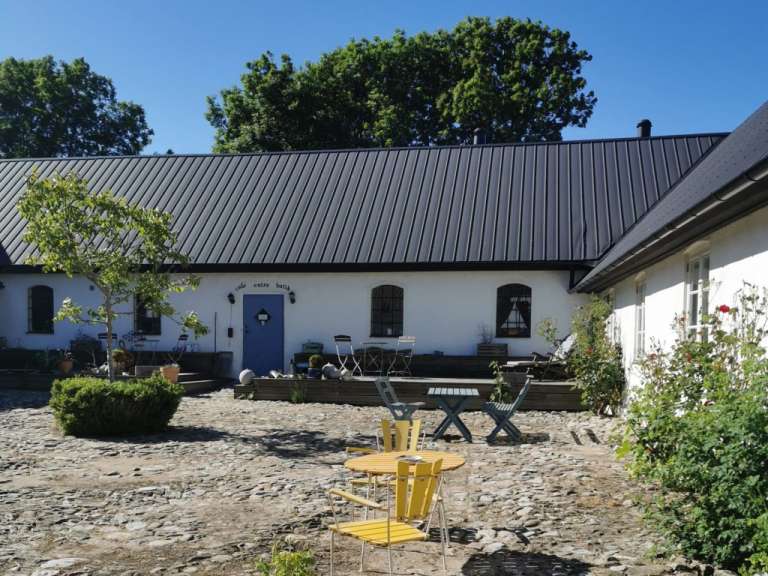 Ein kleines weißes Haus mit einer blauen Tür