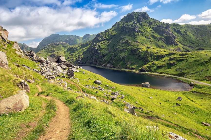 Ein Weg in den Bergen führt zu einem See