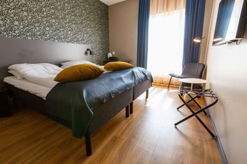 Ein Hotelzimmer mit zwei Betten und einem Stuhl