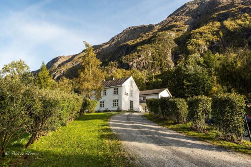 Ein Bild eines weißen Hauses mit einem Berg im Hintergrund