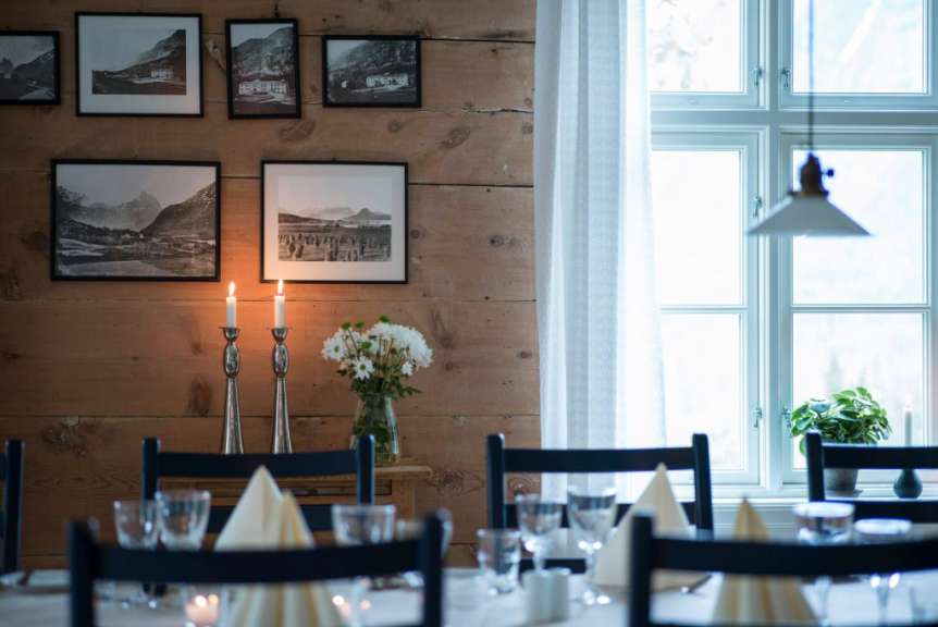 Ein Esszimmer mit einem Tisch und Stühlen und Bildern an der Wand