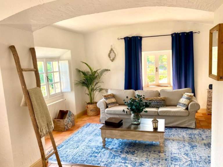 Ein Wohnzimmer mit einem weißen Couchtisch und blauen Vorhängen