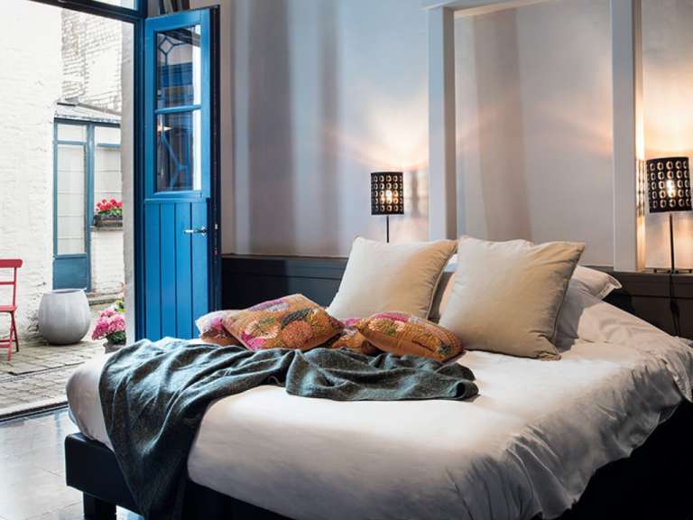 Ein Schlafzimmer mit einem Bett und einer blauen Tür