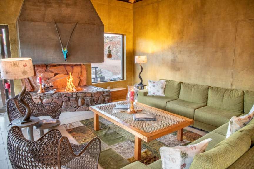 Ein Wohnzimmer mit grünen Möbeln und einem Kamin
