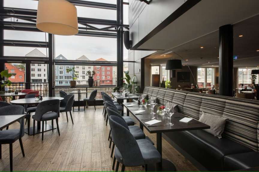 Ein Restaurant mit vielen Tischen und Stühlen und einem großen Fenster