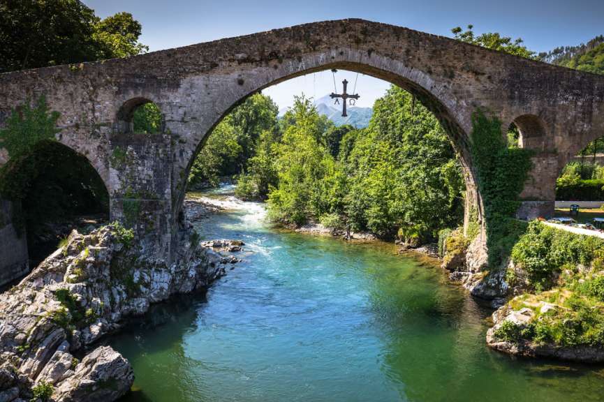 Eine Brücke über einen Fluss mit einem Kreuz darauf