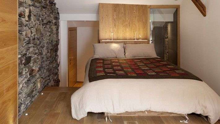 Ein Schlafzimmer mit einem Bett und einer Steinmauer