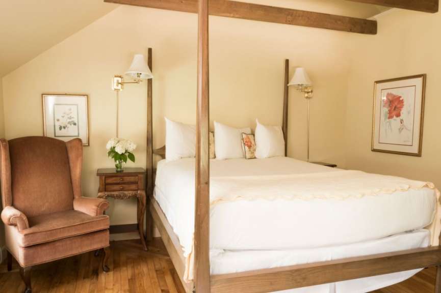 Ein Schlafzimmer mit einem Himmelbett und einem Stuhl