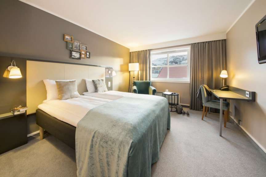 Ein Hotelzimmer mit zwei Betten und einem Stuhl