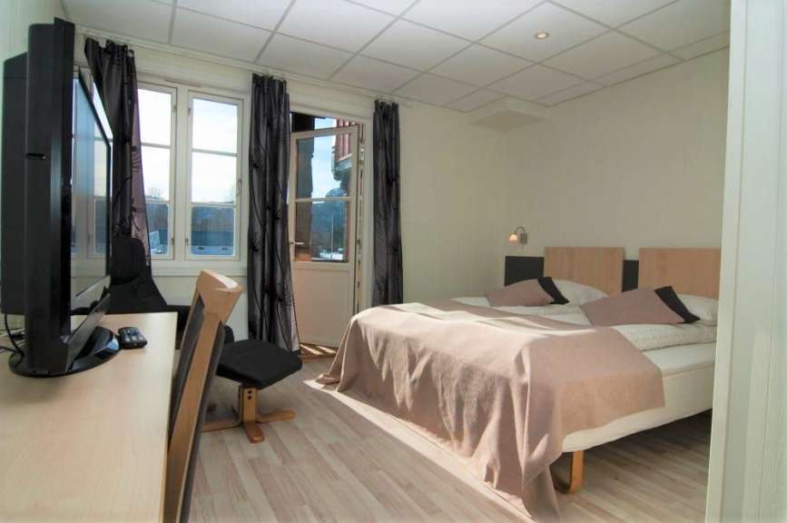 Ein Hotelzimmer mit einem Bett und einem Fernseher