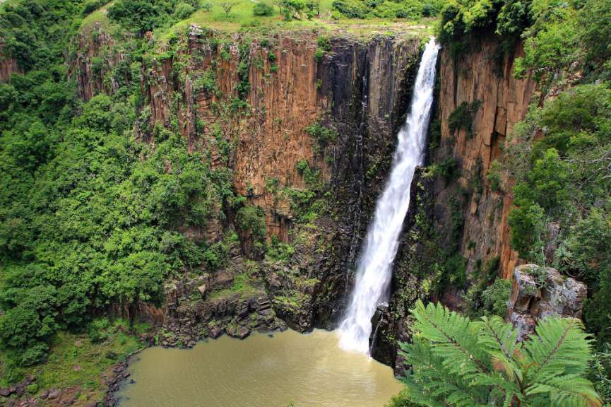 Ein Wasserfall stürzt von einer Klippe in einen Fluss