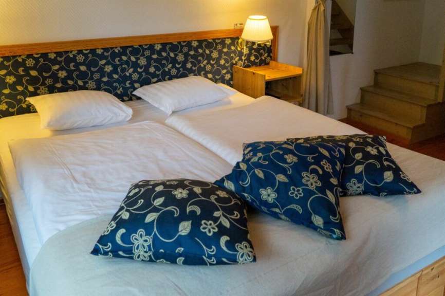 Ein Bett mit blauen Kissen und weißen Bettwäschen