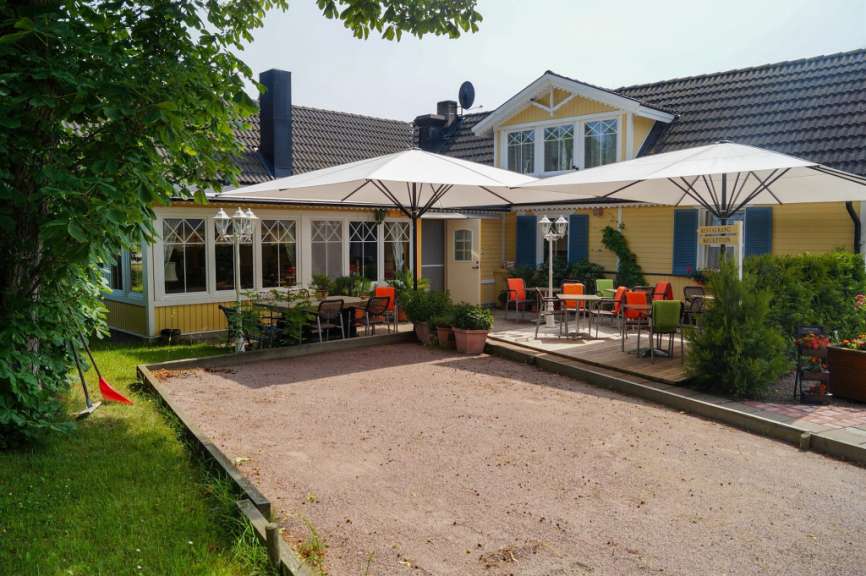 Eine Terrasse mit Tisch und Stühlen vor einem gelben Haus