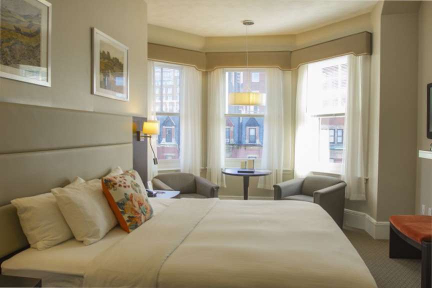 Ein Hotelzimmer mit einem Bett und zwei Stühlen