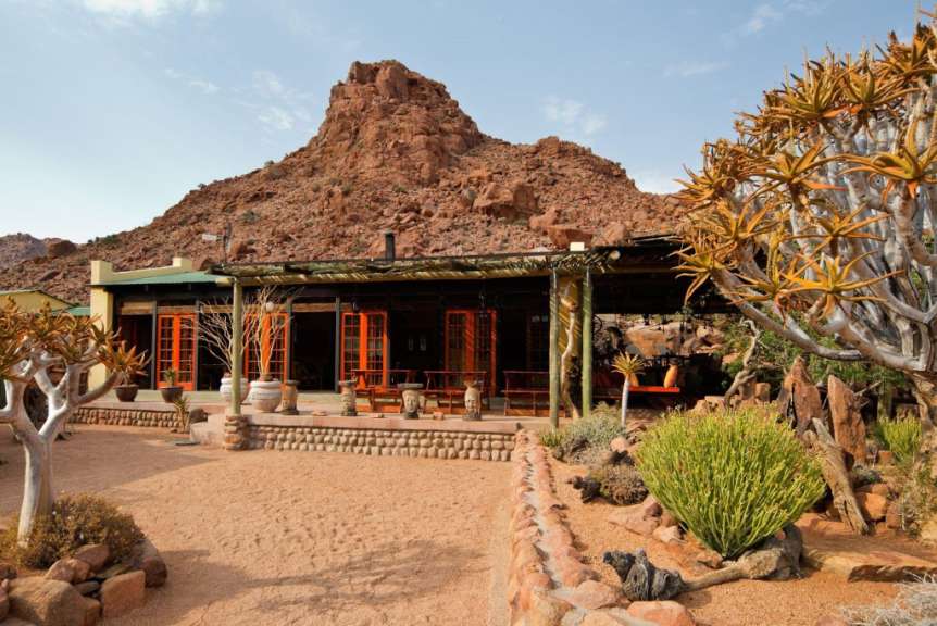 Ein Haus mit einem großen Felsen im Hintergrund