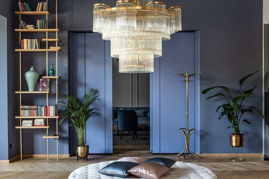 Ein Wohnzimmer mit blauen Wänden und einem großen Kronleuchter