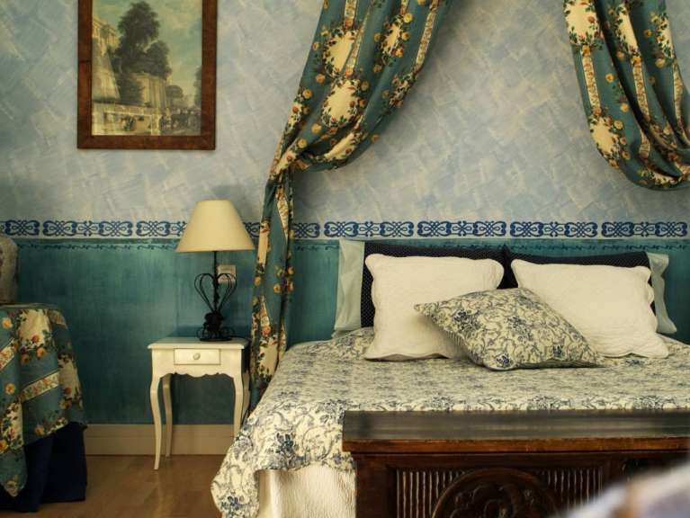 Ein blau-weißes Schlafzimmer mit einem Bett und einer Lampe