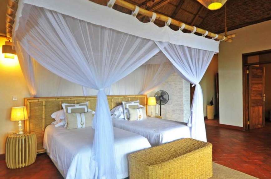 Ein Schlafzimmer mit zwei Betten und weißen Vorhängen