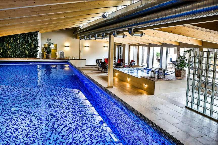 Ein großer Innenpool mit blauem Mosaikboden