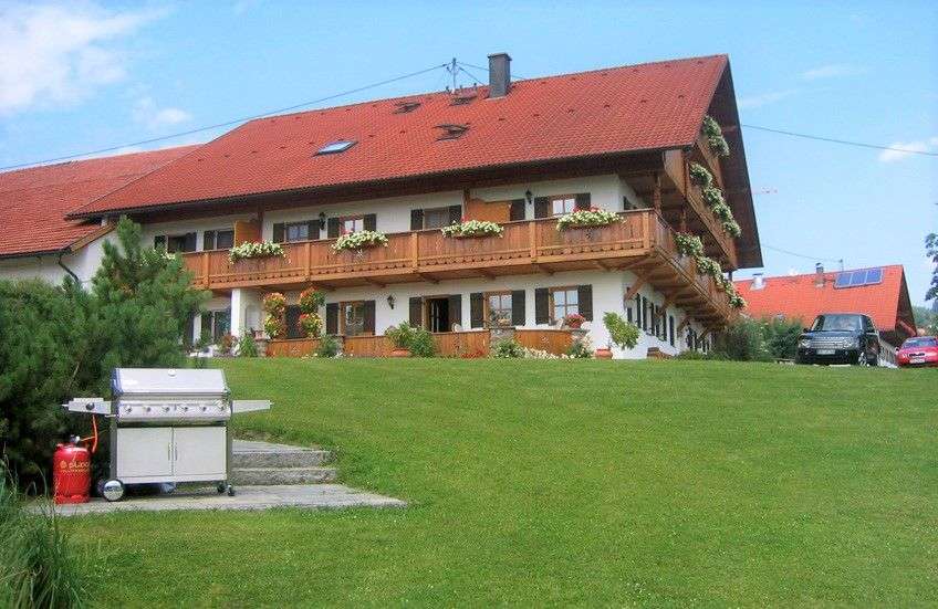 Ein großes Haus mit einem roten Dach und vielen Balkonen