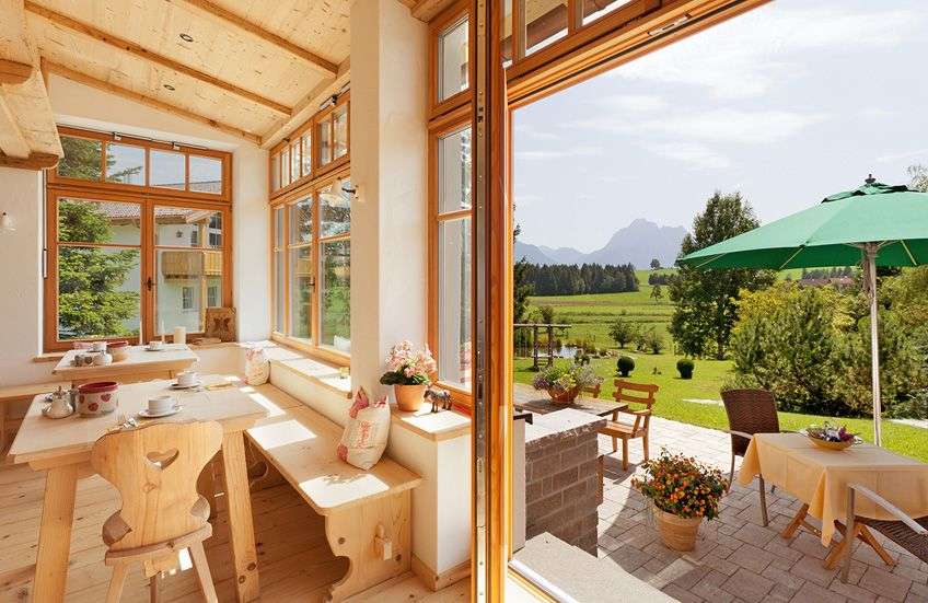Ein Esszimmer mit einem Tisch und Stühlen und einem grünen Regenschirm