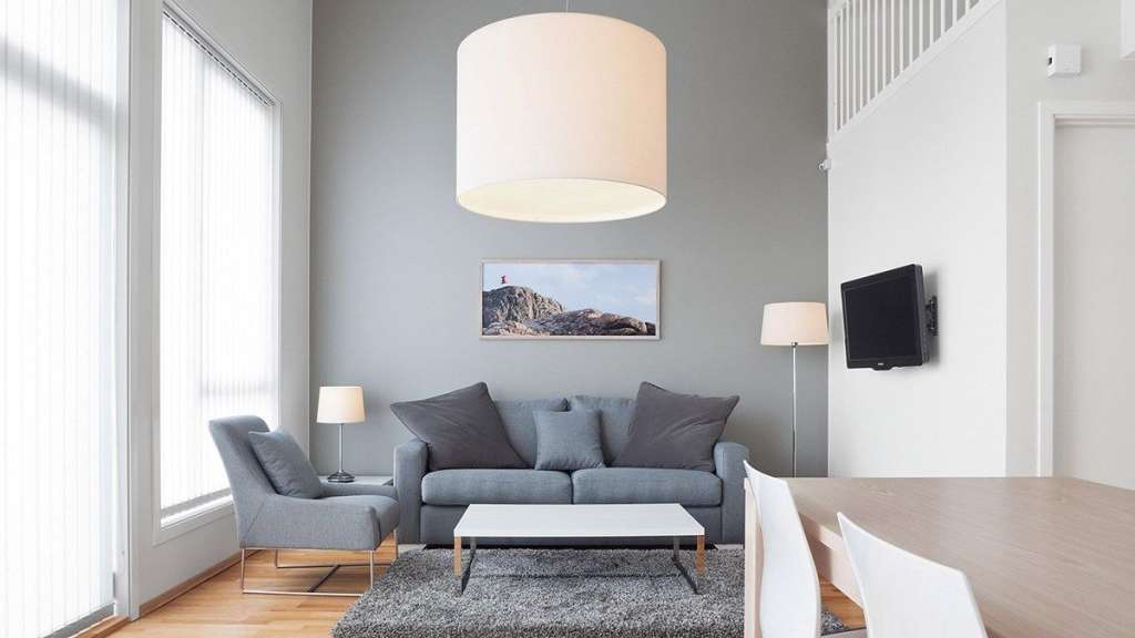 Ein Wohnzimmer mit einer grauen Couch und einem weißen Tisch