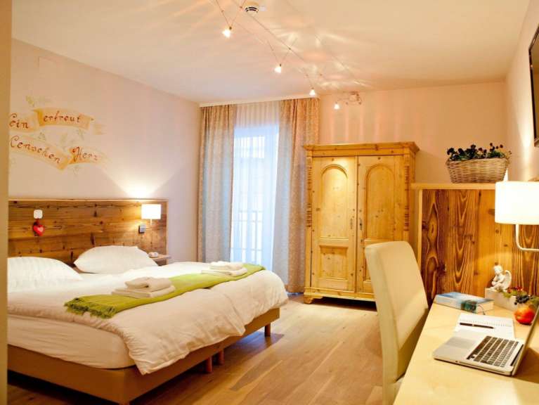 Ein gemütliches Schlafzimmer mit einem Holzbett, einem Kleiderschrank und einem Schreibtisch.