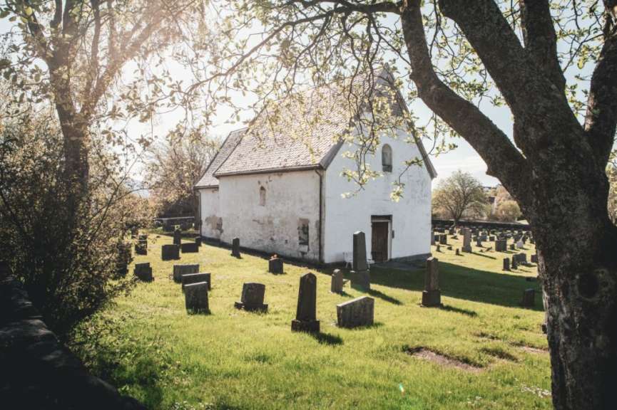 Ein weißes Gebäude mit einem Friedhof davor