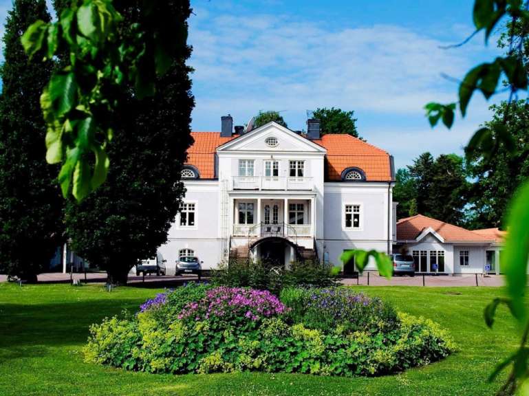 Ein großes weißes Haus mit einem roten Dach