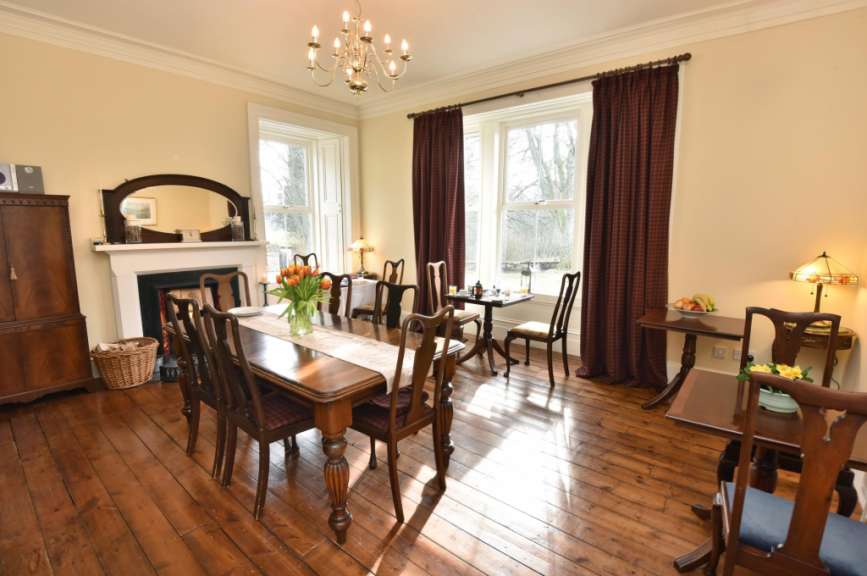 Ein Esszimmer mit einem Tisch und Stühlen und einem Kamin