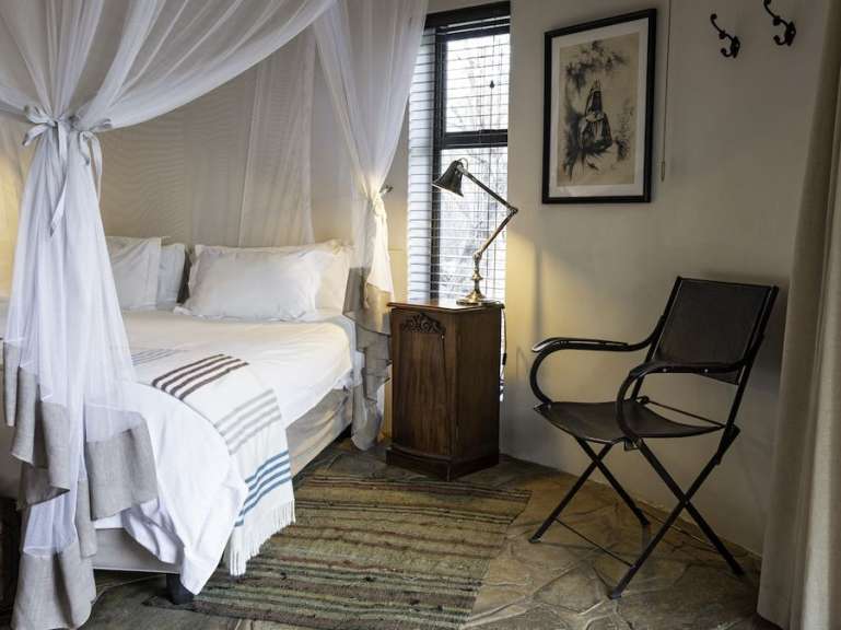 Ein Schlafzimmer mit einem Himmelbett und einem Stuhl