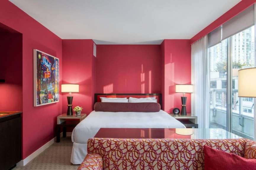 Ein Hotelzimmer mit roten Wänden und einem Bett