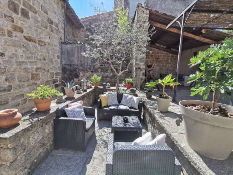 Eine Terrasse mit Möbeln und Pflanzen an einem sonnigen Tag