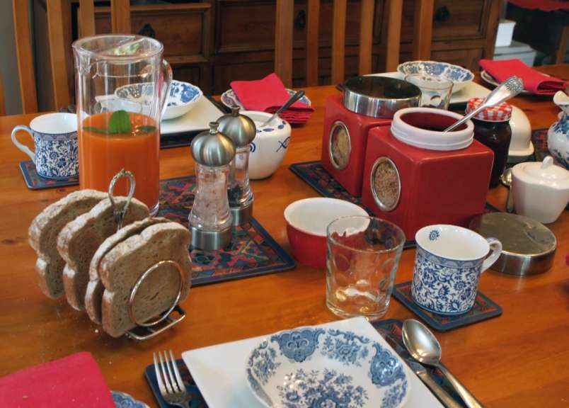 Ein tisch mit tellern und gläsern sowie einem krug orangensaft