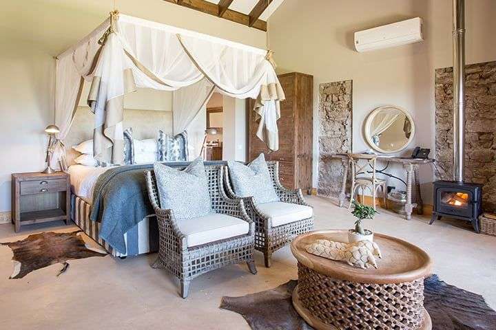 Ein Schlafzimmer mit Himmelbett, Stühlen und einem Tisch