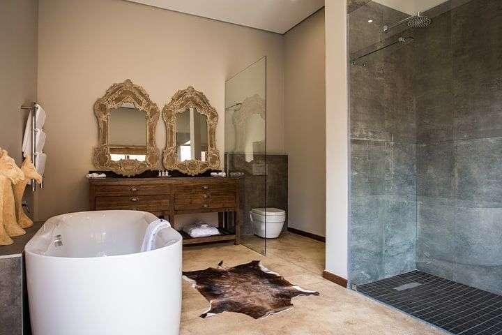 Ein Badezimmer mit einer Badewanne und zwei Spiegeln