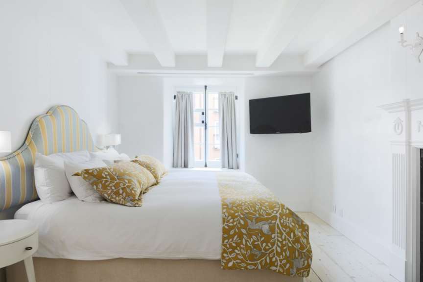 Ein Schlafzimmer mit einem Bett und einem Fernseher an der Wand