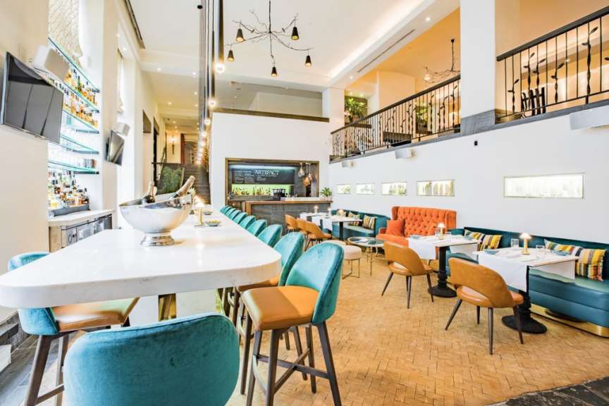 Ein Restaurant mit vielen Tischen und Stühlen und einer Bar
