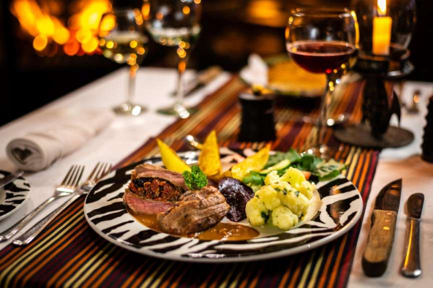 Ein zebramustertes teller mit fleisch und gemüse auf einem tisch
