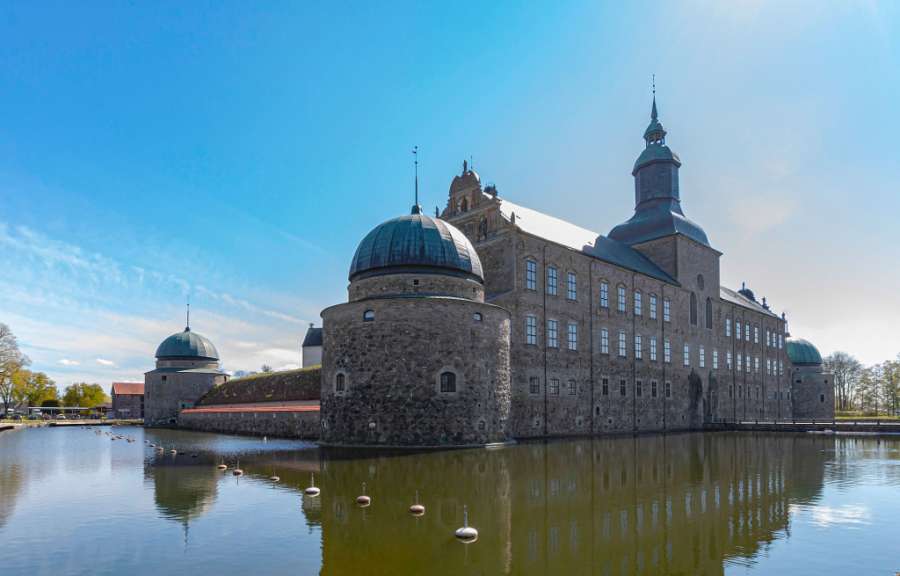 Ein großes Schloss mit einem großen Teich davor