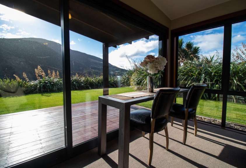 Ein Tisch und Stühle in einem Raum mit Blick auf den Garten