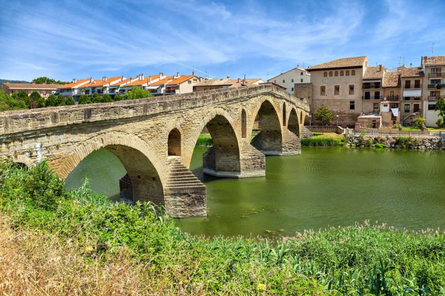 Eine Brücke über einen Fluss mit Gebäuden im Hintergrund