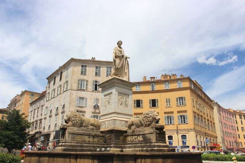Eine Statue einer Frau steht auf einem Sockel neben zwei Löwen