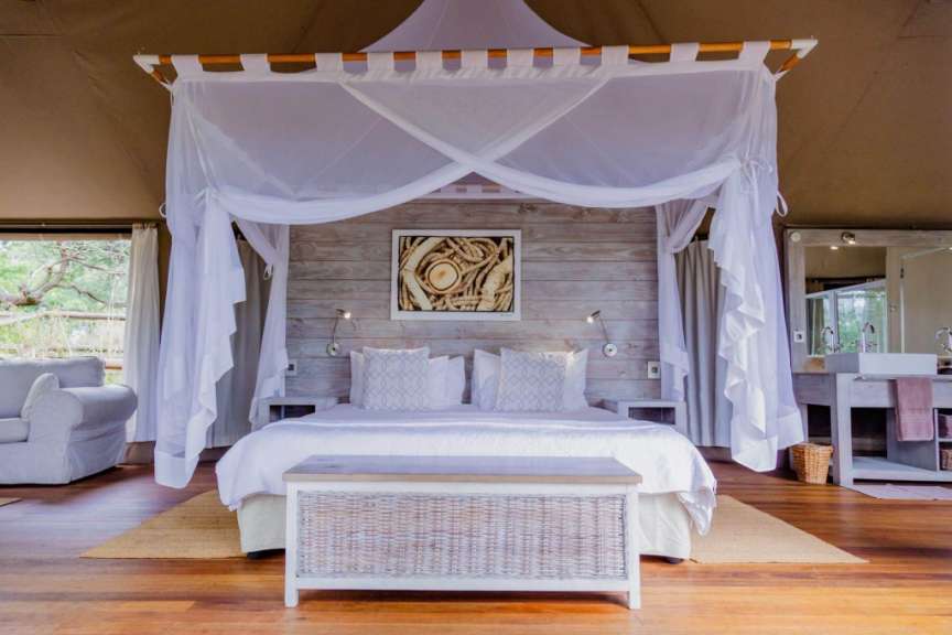 Ein Schlafzimmer mit einem Himmelbett und einem Bild an der Wand